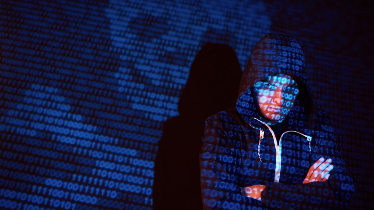 cyber attack with unrecognizable hooded hacker using virtual reality digital glitch effect