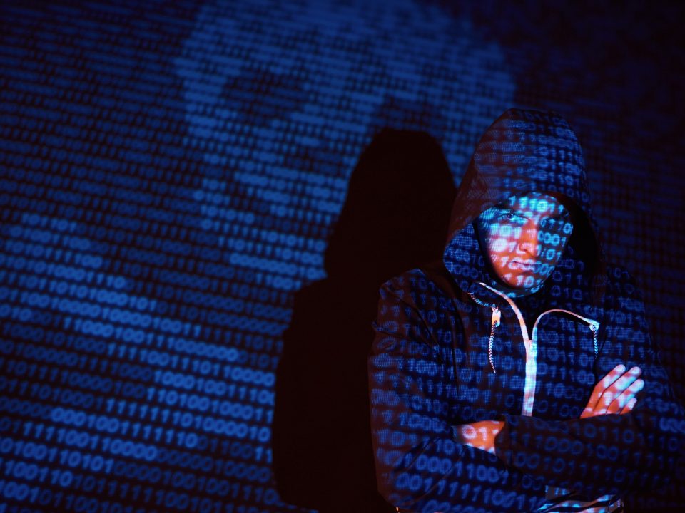 cyber attack with unrecognizable hooded hacker using virtual reality digital glitch effect